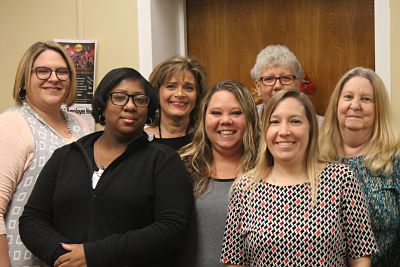 Picture of seven Business Office female staff members standing in office.